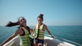 Two beautiful girls enjoying a trip on a boat dancing Royalty Free Stock Photo