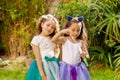 Two happy beautiful little girls playing with soap bubbles on a summer nature, one girl is wearing a blue ears tiger Royalty Free Stock Photo