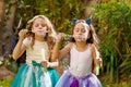 Two happy beautiful little girls playing with soap bubbles on a summer nature, one girl is wearing a blue ears tiger Royalty Free Stock Photo