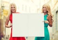 Two happy blonde women with blank white board Royalty Free Stock Photo