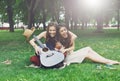 Two happy boho chic stylish girlfriends picnic in park