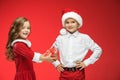 Two happy boy and girl in santa claus hats with gift boxes at studio Royalty Free Stock Photo