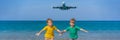 Two happy boys have fun on the beach watching the landing planes. Traveling on an airplane with kids concept. Text space Royalty Free Stock Photo