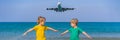 Two happy boys have fun on the beach watching the landing planes. Traveling on an airplane with kids concept. Text space Royalty Free Stock Photo