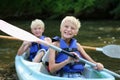 Two happy boys kayaking on the river