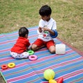 Two happy boys in society park, happy Asian brothers who are smiling happily together. Brothers play outdoors in summer, best Royalty Free Stock Photo