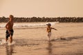 Two happy brothers, school boys playing on the beach and splashing in the sea on a summer day. Royalty Free Stock Photo