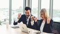 Two happy business people celebrate at office