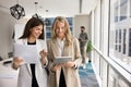 Two happy business professional women analyzing electronic and paper documents Royalty Free Stock Photo
