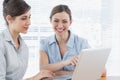 Two happy businesswomen working on laptop together Royalty Free Stock Photo