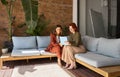 Two busy happy business women talking using tab working sitting in office. Royalty Free Stock Photo