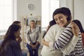 Smiling young women embracing each other in support group meeting or therapy session Royalty Free Stock Photo