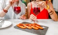 Happy cheerful girl friends drinking wine and having lunch at seafood restaurant Royalty Free Stock Photo