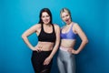 Two happy and cheerful girls dressed in fitness bodysuits, best friends having fun. Royalty Free Stock Photo