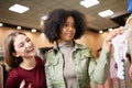 Two happy chic young mixed race woman shopping for lingerie in a clothing boutique with one holding panties as they Royalty Free Stock Photo