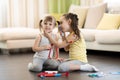 Two happy children, cute toddler girl and older sister, playing doctor and hospital using stethoscope toy and other medical toys, Royalty Free Stock Photo