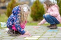 Two happy children drawing with colorful chalks on a sidewalk. Summer activity for small kids. Royalty Free Stock Photo