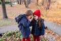 Two happy children hugging in autumn park. Close up sunny lifestyle fashion portrait of two beautiful caucasian girls outdoors,wea Royalty Free Stock Photo