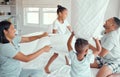 Two happy children laughing and enjoying pillow fight with parents in bedroom at home. Joyful kids daughter and son Royalty Free Stock Photo