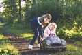 Two happy children playing with big old toy car in autumn forest, outdoors. Kid boy pushing and driving car with little Royalty Free Stock Photo
