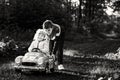 Two happy children playing with big old toy car in autumn forest, outdoors. Kid boy pushing and driving car with little Royalty Free Stock Photo