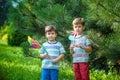Two happy children playing in garden with windmill pinwheel. Ado Royalty Free Stock Photo