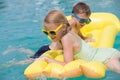 Two happy children playing on the swimming pool at the day time.