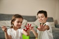 Two happy children showing their hands smeared with colored paints to the camera during coloring eggs for Easter Royalty Free Stock Photo