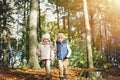 Two happy children walking through the forest