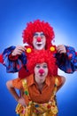 Two happy clowns playing on blue background