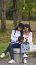 Two college students watching something on digital tablet and sitting together in the campus. Royalty Free Stock Photo