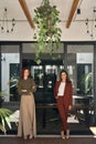 Two happy smiling business women standing at work in office. Vertical portrait. Royalty Free Stock Photo