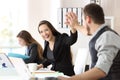 Two happy coworkers celebrating success at office