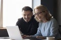 Two happy diverse colleagues working on project together at laptop Royalty Free Stock Photo