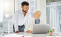 Two happy diverse colleagues working together on a laptop and digital tablet device in an office boardroom. Young mixed Royalty Free Stock Photo