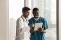 Two happy diverse doctors using tablet for healthcare discussion Royalty Free Stock Photo