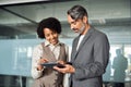 Two happy diverse professional business partners working in office with tablet. Royalty Free Stock Photo