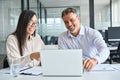 Two happy diverse professional colleagues working in office using laptop. Royalty Free Stock Photo