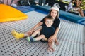 Two happy emotions children, brothers playing and having fun while jumping on bouncing trampoline in playground in summer. Hug, Royalty Free Stock Photo