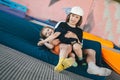 Two happy emotions children, brothers playing and having fun while jumping on bouncing trampoline in playground in summer. Hug, Royalty Free Stock Photo