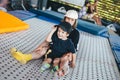 Two happy emotions children, brothers playing and having fun while jumping on bouncing trampoline in playground in summer. Hug, Royalty Free Stock Photo