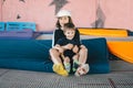 Two happy emotions children, brothers playing and having fun while jumping on bouncing trampoline in playground in summer. Hug, Royalty Free Stock Photo