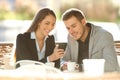 Two executives using a smart phone in a coffee shop Royalty Free Stock Photo
