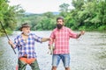 Two happy fisherman with fishing rod and net. hunting tourism. father and son fishing. Camping on the shore of lake. Big Royalty Free Stock Photo