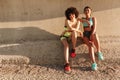 Two happy fitness girl relaxing on pier after training Royalty Free Stock Photo