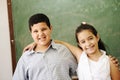 Two happy friends in front of green classroom boar Royalty Free Stock Photo