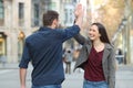 Happy friends giving high five in the street