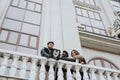 Two happy friends interact with a smart phone capturing a selfie moment on a historic balcony, exhibiting joy and Royalty Free Stock Photo
