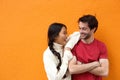 Two happy friends laughing against orange background Royalty Free Stock Photo