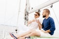 Happy friends sitting together on a deck of a yacht and drinking an alcoholic drink. Royalty Free Stock Photo